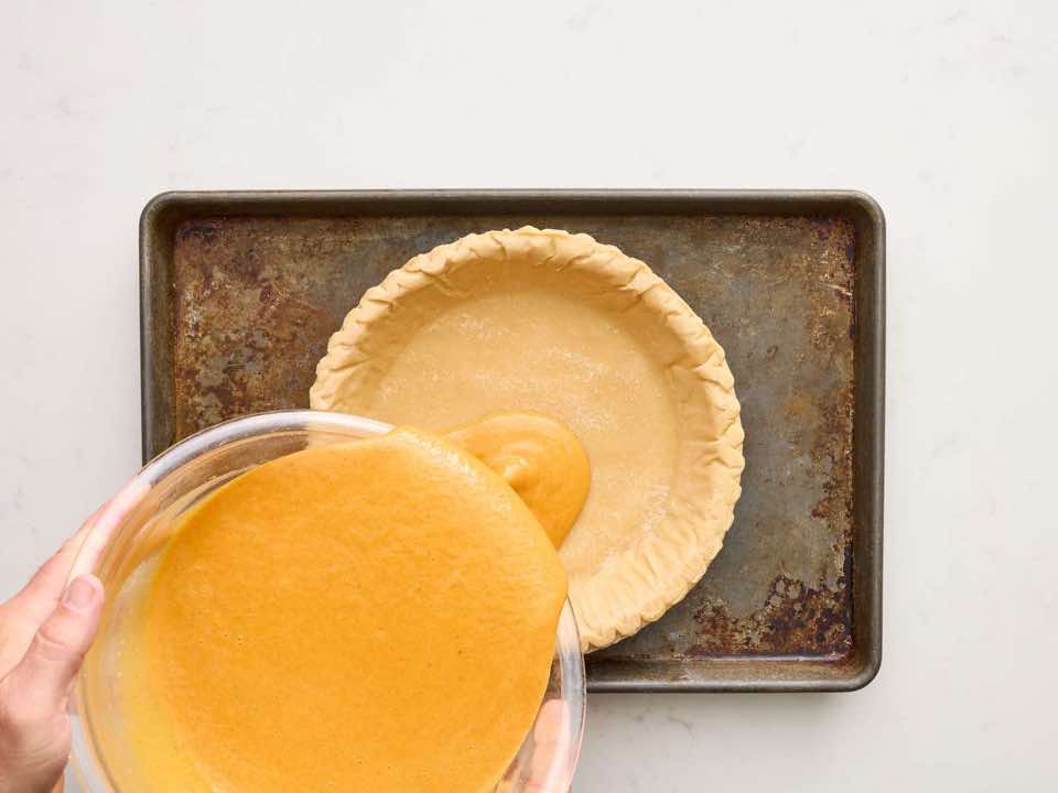 Pie filling being poured into pie crust.